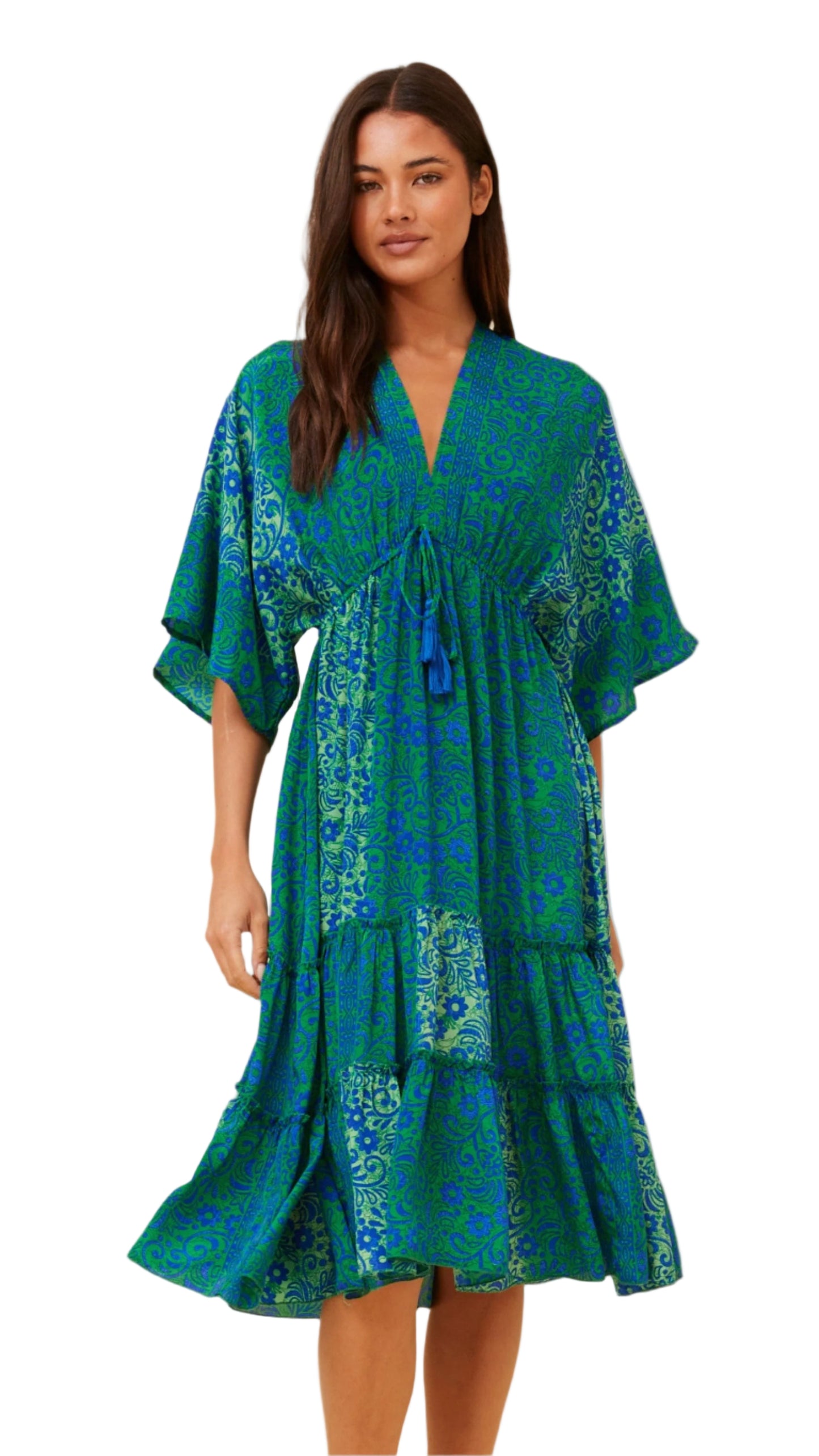 Woman wearing a vibrant blue and green floral Esmerelda Midi Dress with tassel tie and tiered hem – front view.