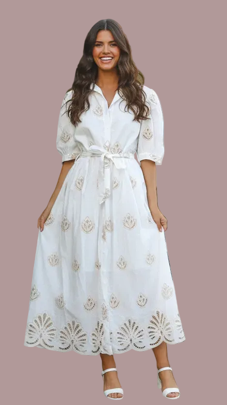 Woman wearing a white dress with floral patterns on a brown background