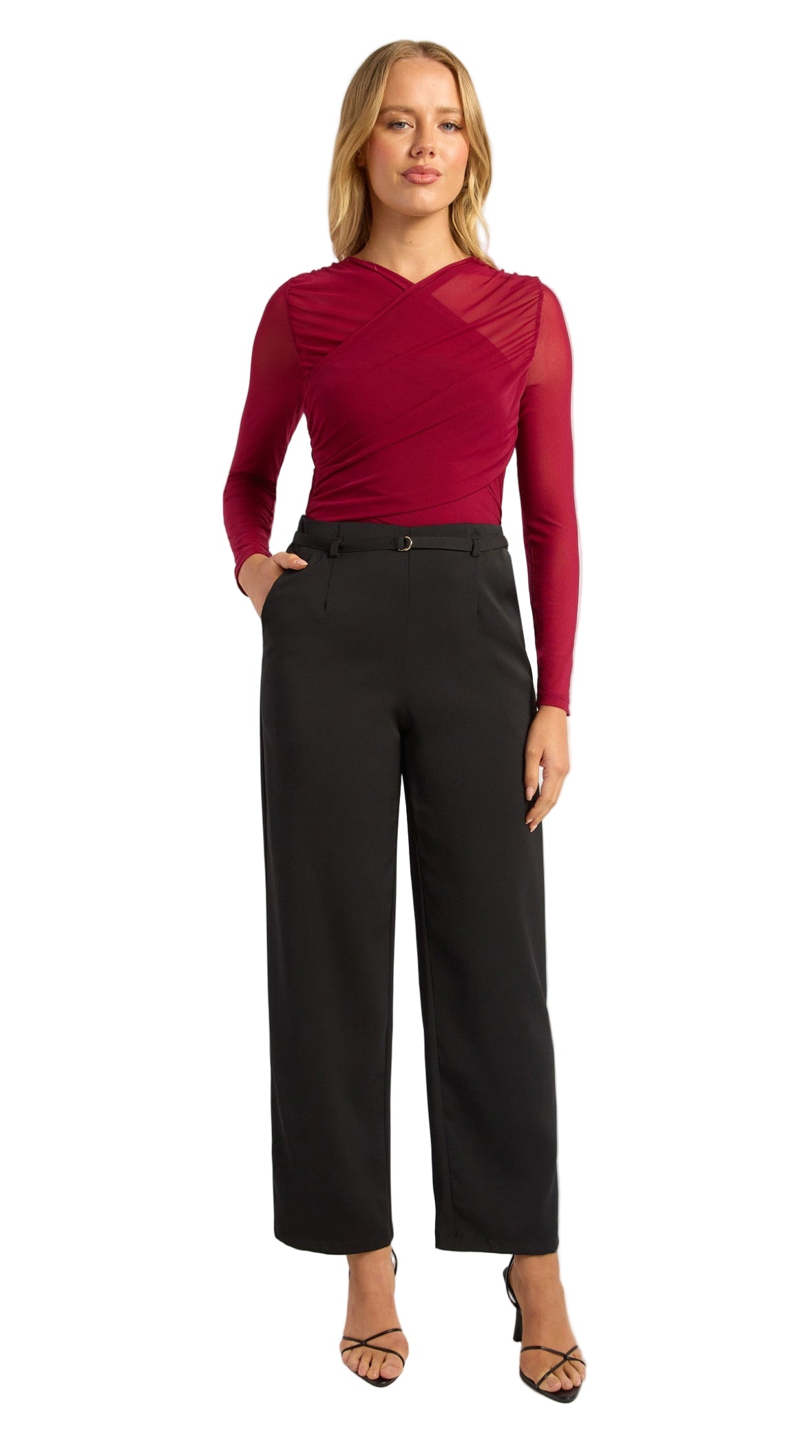 Woman wearing a red top and black pants on a white background