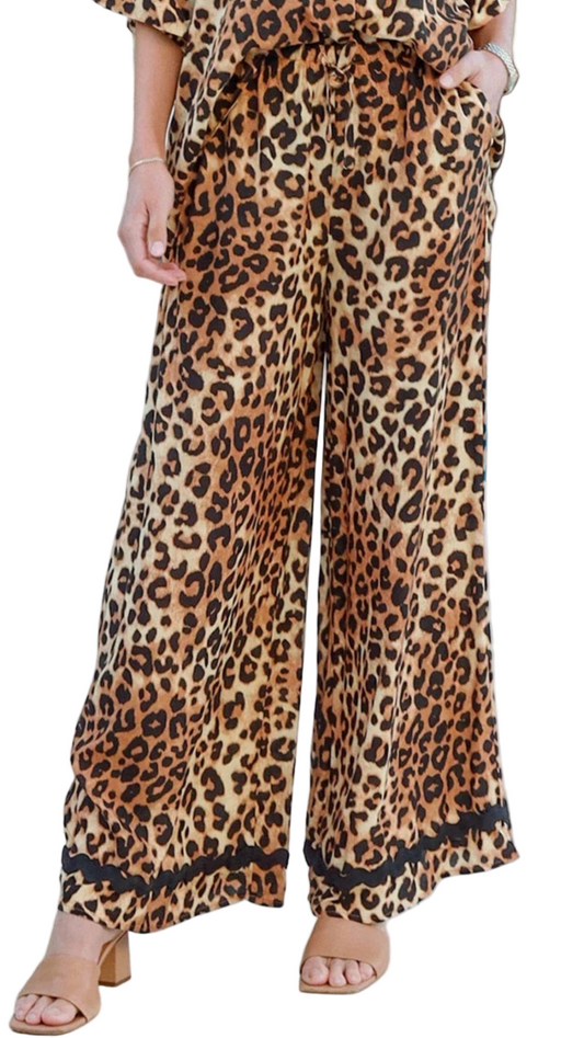 Leopard-print wide-leg pants with bold border detail, styled poolside.