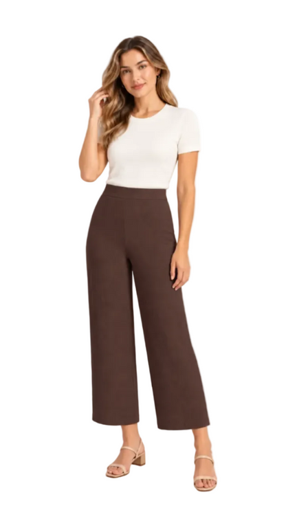 A woman modeling a white short-sleeve crewneck top and dark brown wide-leg cropped pants, paired with beige heeled sandals, against a plain white studio background.