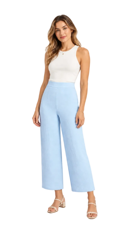 A woman modeling light blue wide-leg cropped pants with a white sleeveless top and beige sandals, standing against a plain white background.