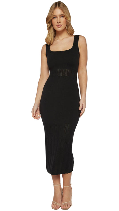 Woman wearing a black sleeveless dress on a plain background