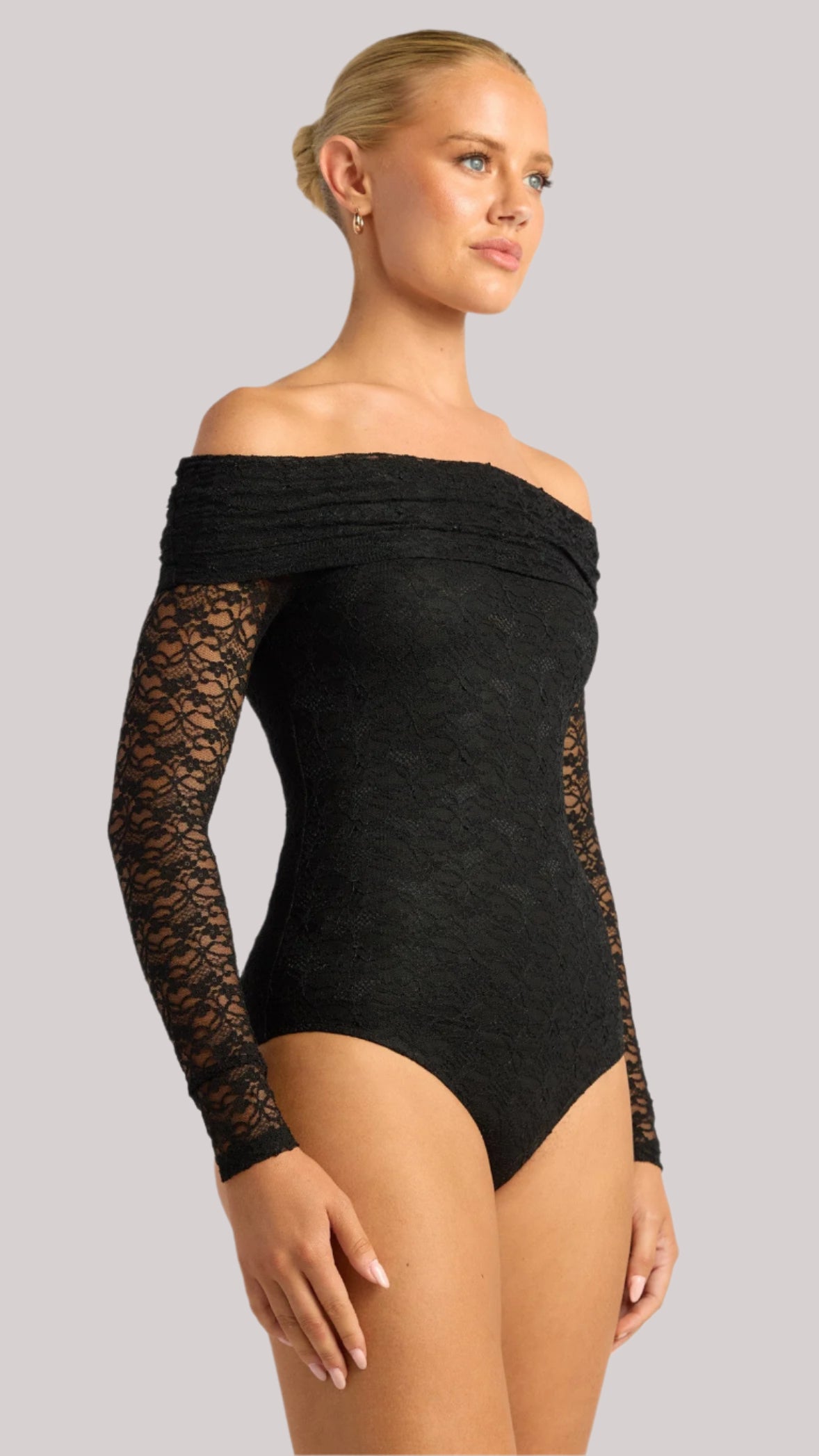 Front view of model wearing the Amara Lace Bodysuit – off-shoulder with long lace sleeves.