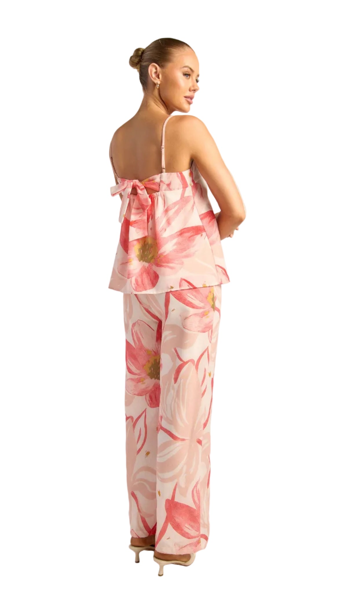 Woman wearing a pink floral pants set on a white background