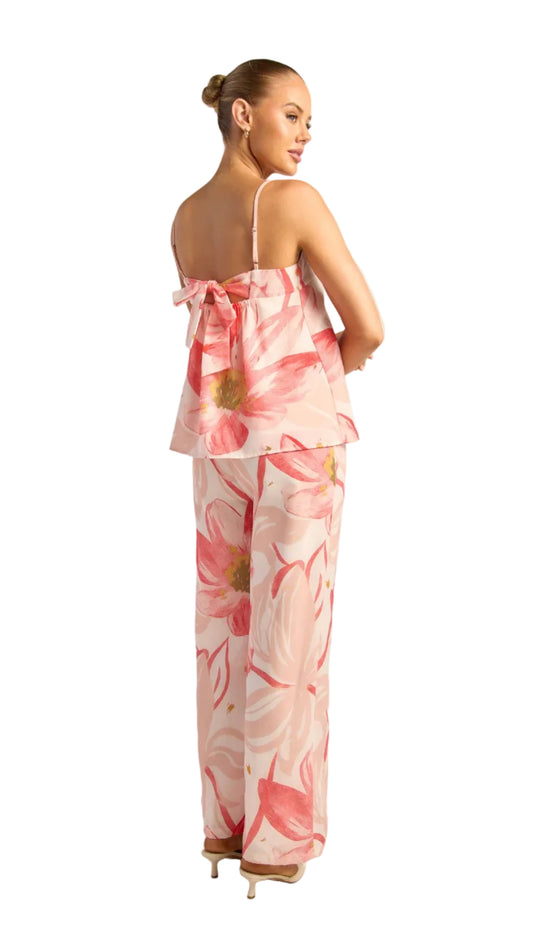 Woman wearing a pink floral pants set on a white background