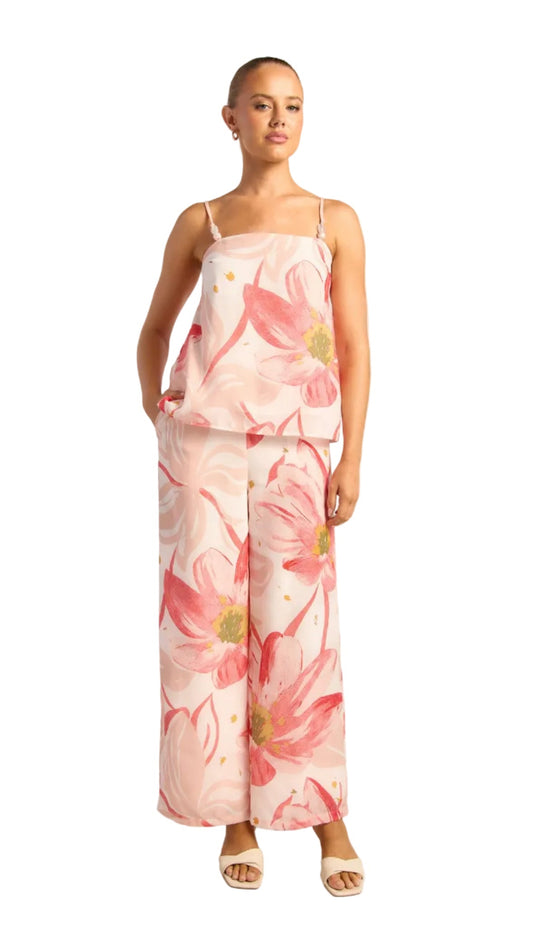 Woman wearing a floral jumpsuit on a white background