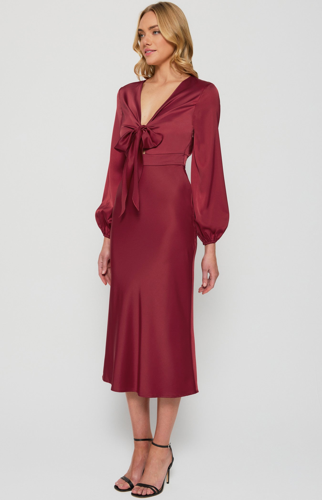 Side angle of model in wine satin midi dress highlighting silhouette and cut