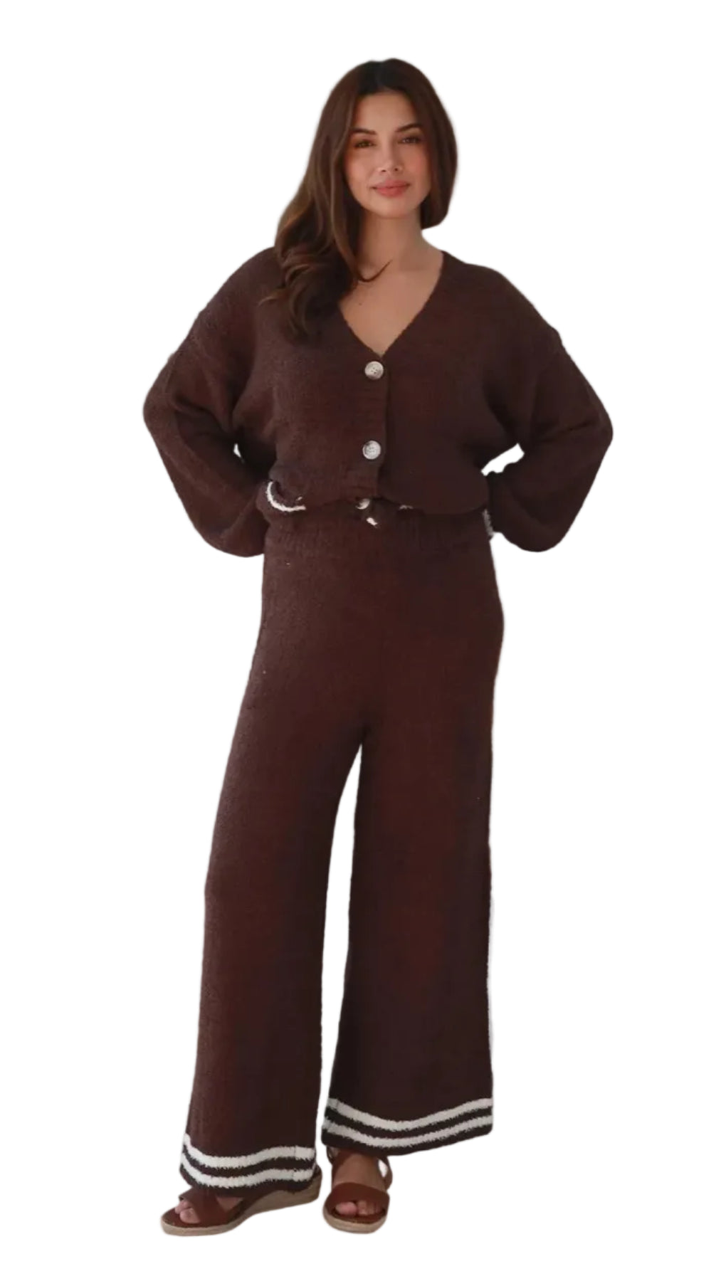 A woman modeling a dark brown knit matching set consisting of a button-front cardigan and wide-leg pants with white striped trim at the hems, shown against a plain white background.