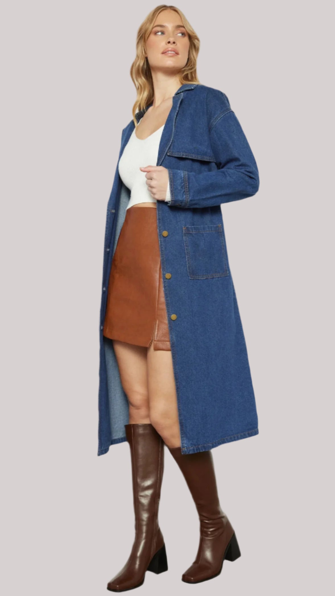 Open style: Denim coat worn open over mini skirt and top, styled with brown boots