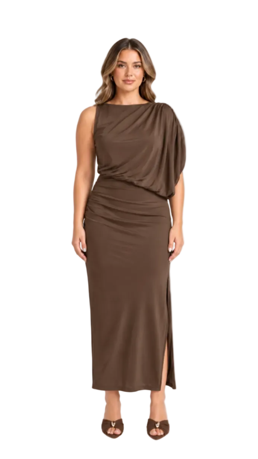 A woman modeling a sleeveless, draped maxi dress in a rich brown color, featuring an asymmetrical draped neckline and a gathered skirt with a side slit, set against a plain light gray studio background.