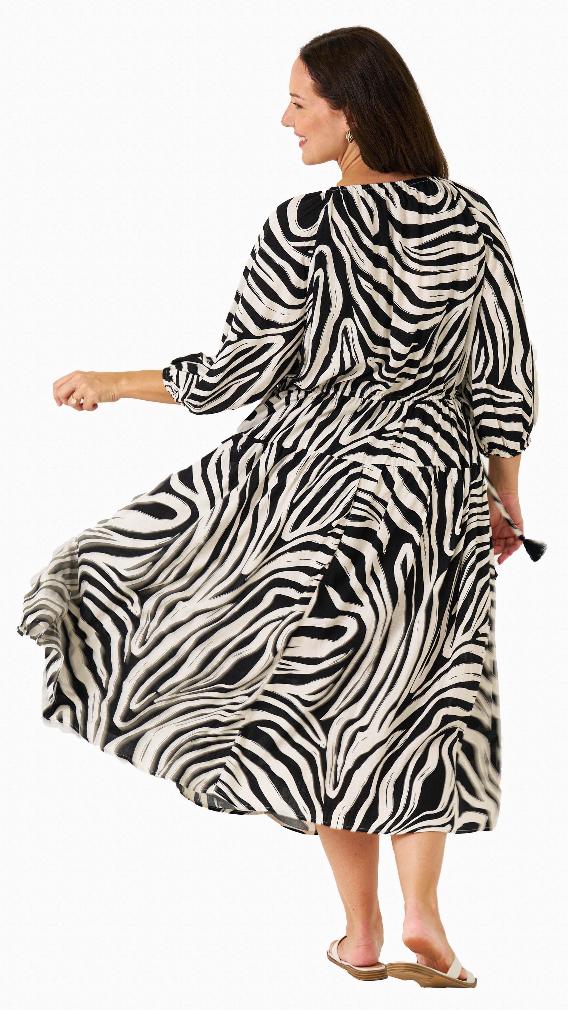 Zeeba Midi Dress in black shown walking with puff sleeves and flowing skirt.