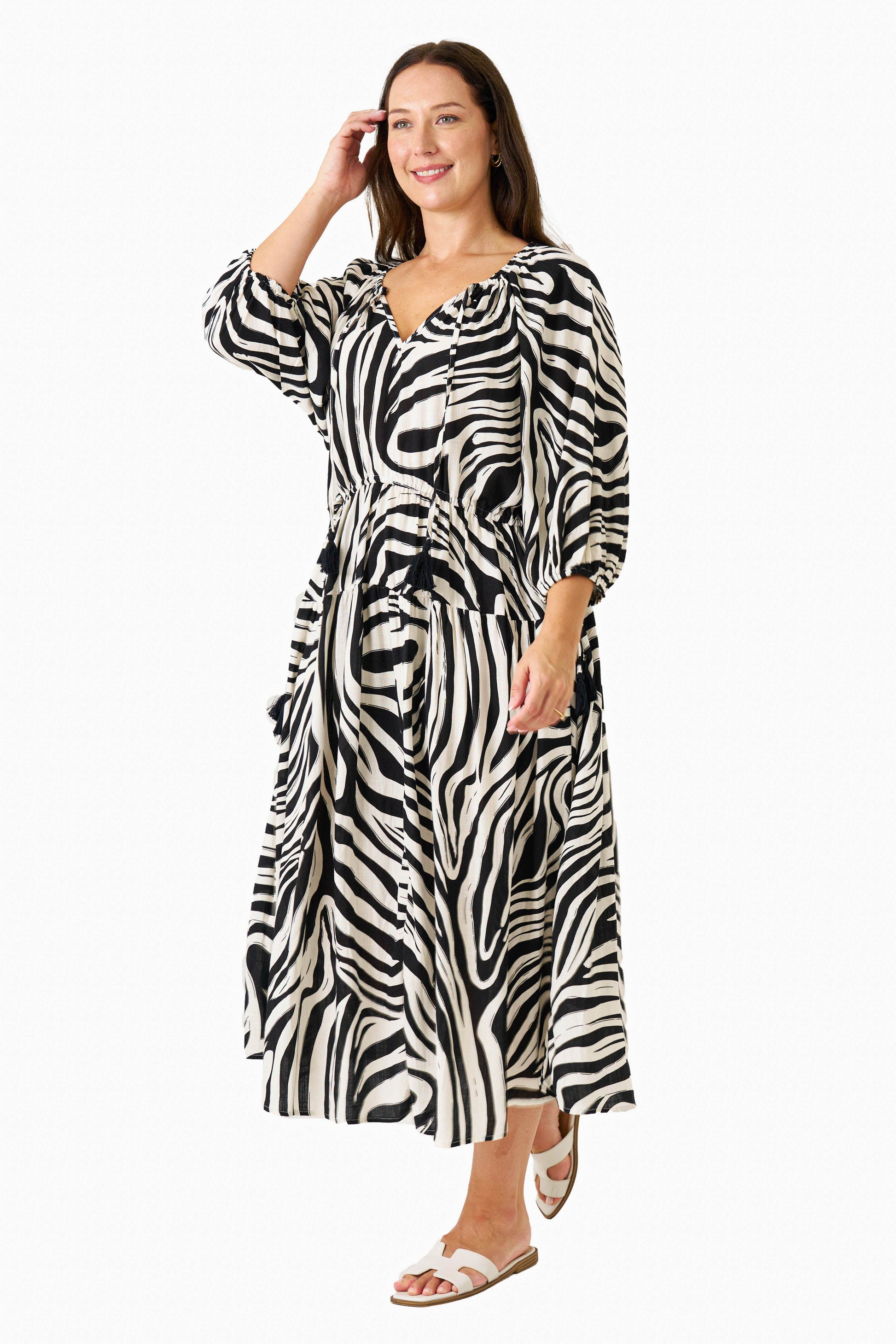 Model wearing the Zeeba Midi Dress in chocolate, smiling with hand in hair – full-length front view