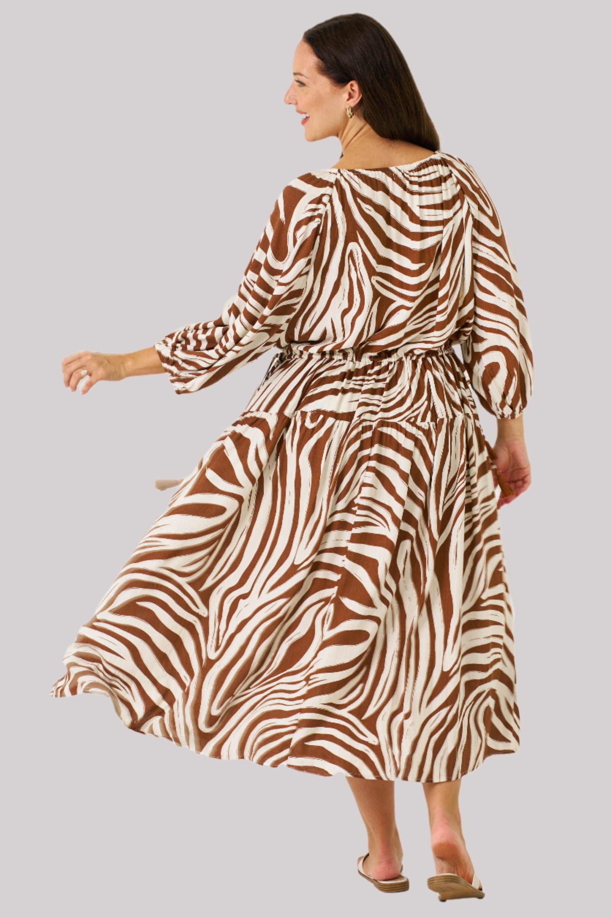 Zeeba Midi Dress in chocolate shown walking with puff sleeves and flowing skirt.