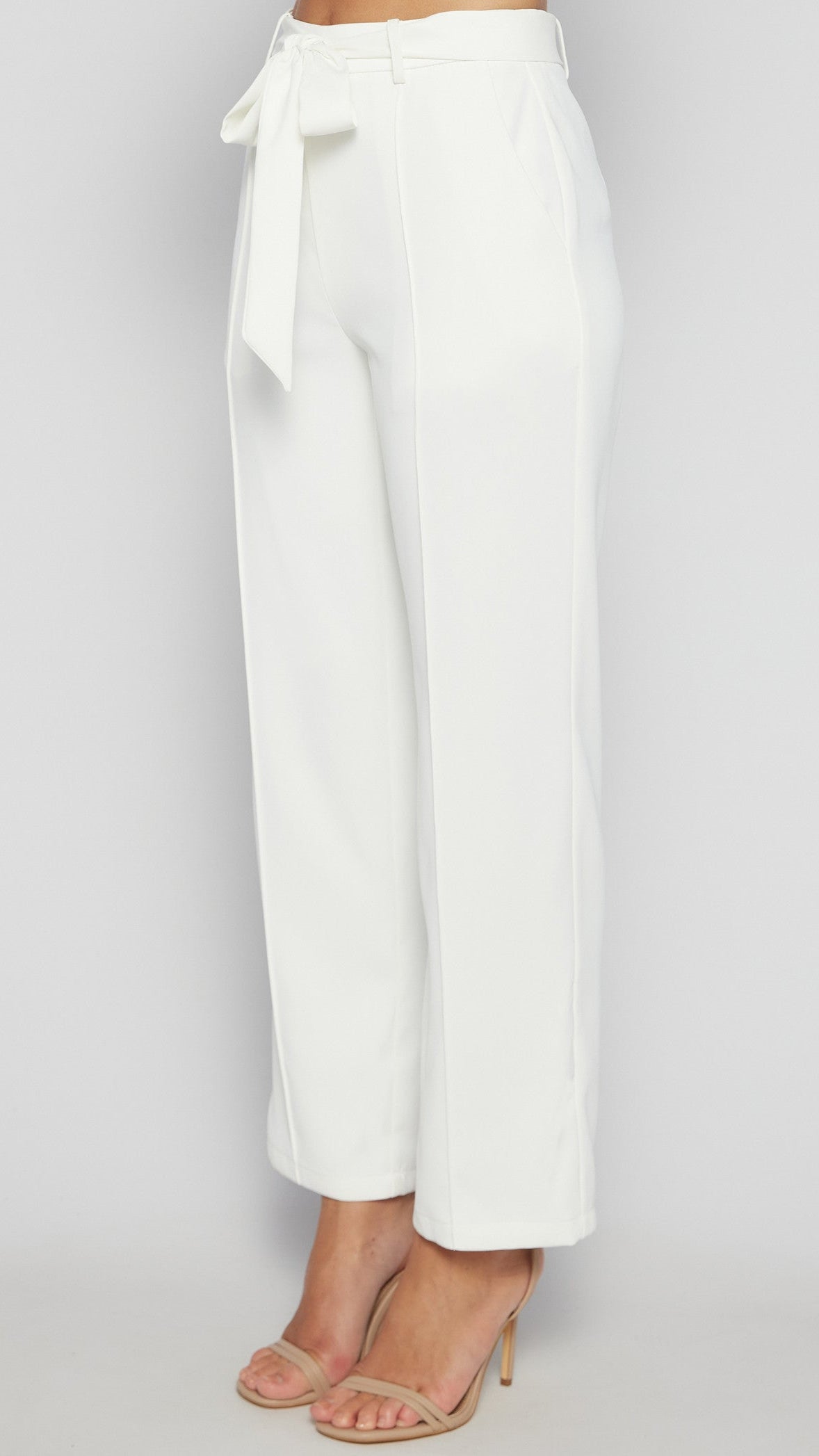White wide-leg pants with a tie waist on a light gray background