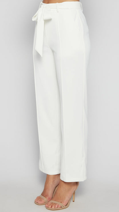 White wide-leg pants with a tie waist on a light gray background