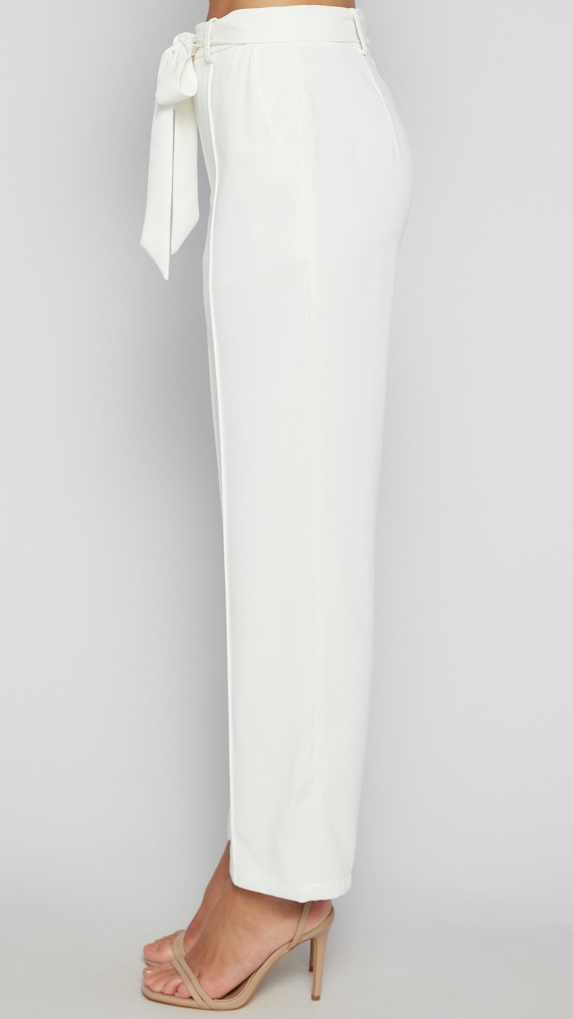 White pants with a tie waist on a gray background