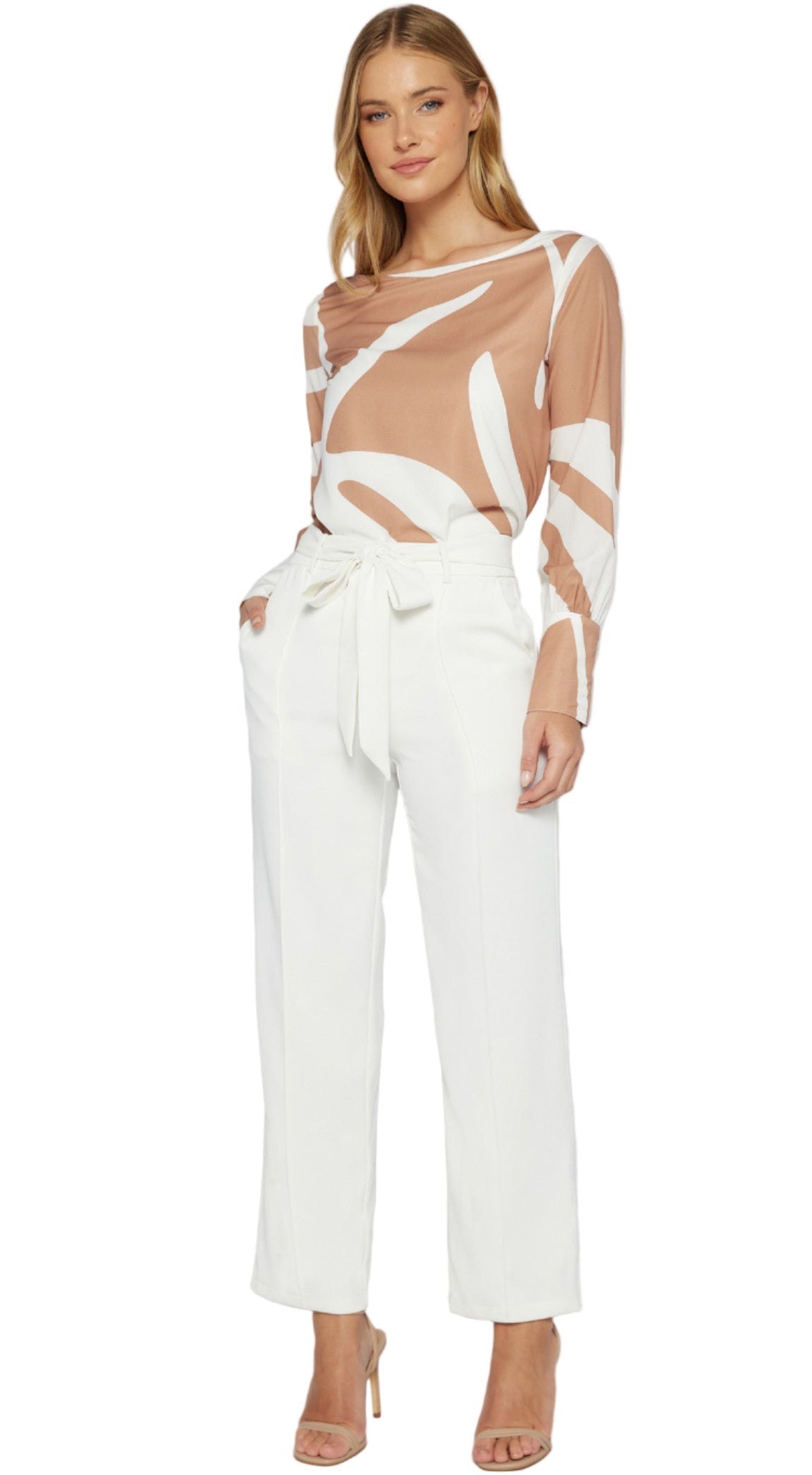 Woman wearing a sheer top and white pants on a plain background